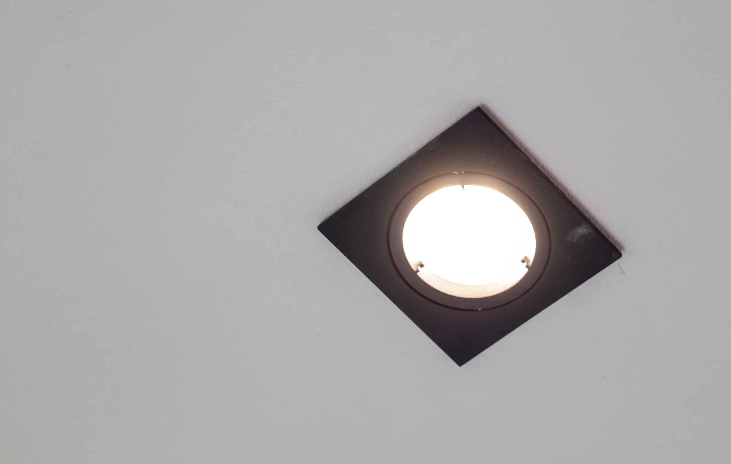 Square recessed light installed in a white ceiling